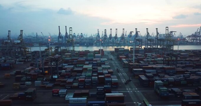 Aerial View of a Massive Cargo Terminal with Shipping Containers and Cranes at Sunset