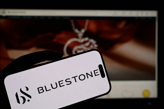 Kiel, Germany - 05-20-2026: Smartphone displaying Indian jewelry ecommerce company BlueStone logo in front of companys webpage