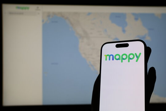 Kiel, Germany - 05-20-2026: Smartphone displaying French mapping software company Mappy logo in front of companys webpage