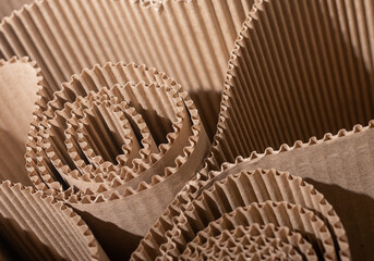 Obraz premium Corrugated cardboard rolls in close up. Brown packaging texture with folded paper layers. Abstract industrial background for sustainable design and recycling..
