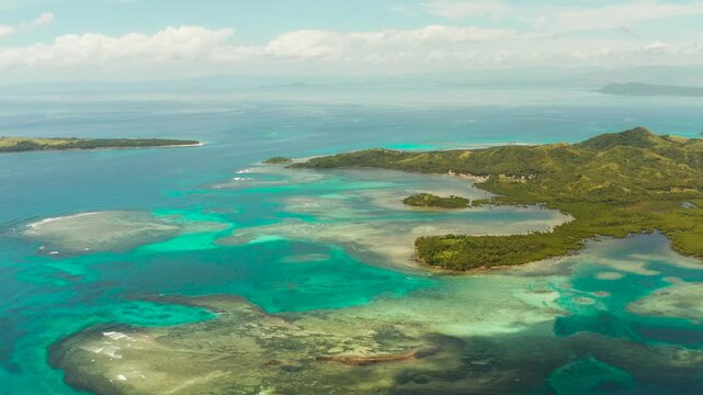 Islands are surrounded by an atoll and a coral reef with blue water top view. Bucas grande, Philippines. Summer and travel vacation concept.