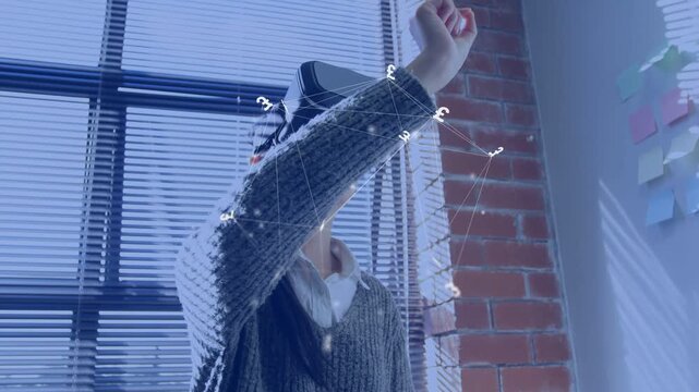 Woman putting on VR headset, reaching and pinching floating nodes, testing tech interface in loft