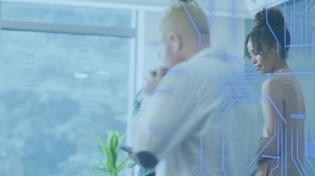 Lead man tapping phone and starting tech UI overlaying, woman reviewing blue binder, peer passing