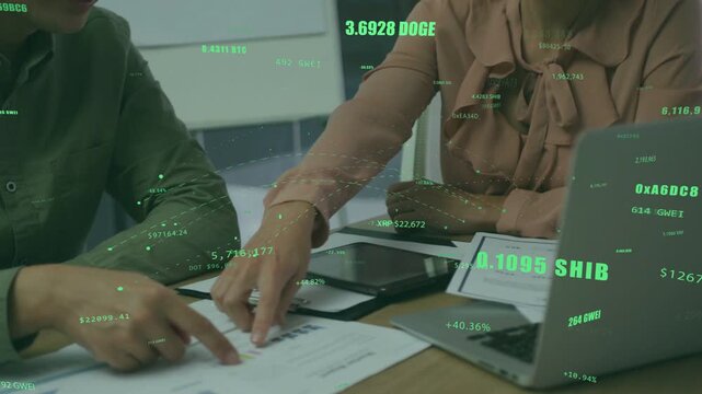 Woman leaning in and pointing at graph, man tapping laptop while analyzing crypto values overlay