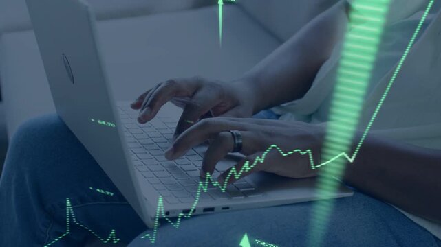 Man typing on laptop in living room, activating animated financial charts and rising numeric arrows