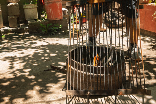 Parrillero encendiendo brasas para asado argentino tradicional en patio familiar durante fin de semana