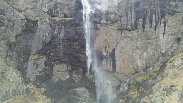 Aerial Pullback from Waterfall to Wide Mountain Landscape