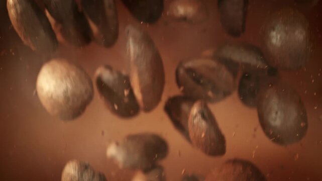 Super Slow Motion Shot of Falling Coffee Beans and Ground Coffee on Brown Background at 1000fps.