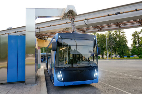 Bus at a charging station has its pantograph connected to a high voltage connector the final stop of the route