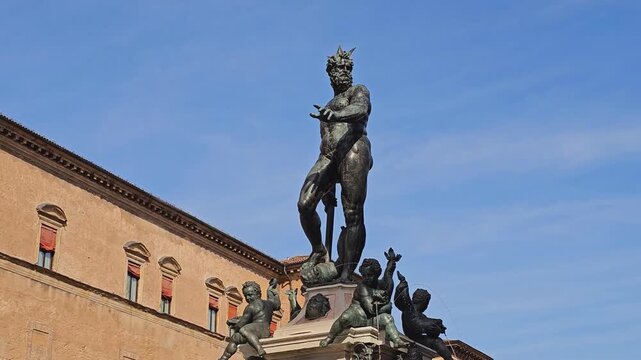 Close street-level view of the Neptune statue at the Fountain of Neptune in Bologna, Emilia-Romagna, Italy, on a sunny day.