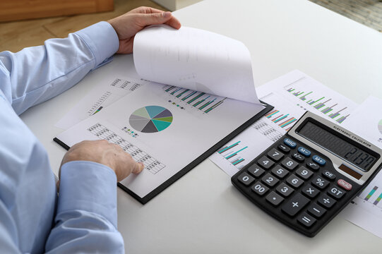 Office worker reviewing company balance sheet, financial paperwork
