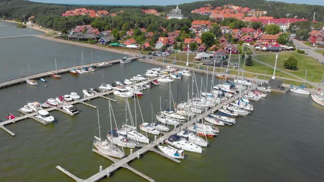 Cinematic high quality 4K aerial footage of the Nida boat and yacht harbor located on the Curonian Spit peninsula between the Curonian Lagoon and the Baltic Sea in Lithuania
