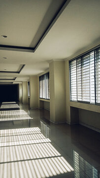 Modern empty building corridor with sunlight shadows from side windows