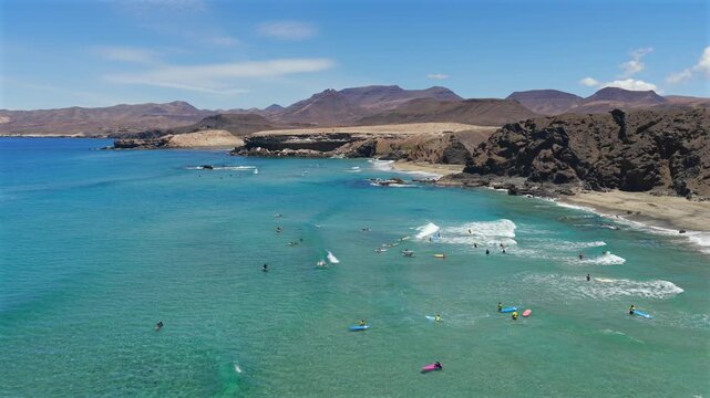 Aerial View of Beginners Catching Waves with a Surf School at Playa de Mal Nombre, Fuerteventura