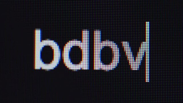Qingdao,China-May.20.2026:A macro photo of an electronic screen displaying the uppercase text "BDBM" with a vertical typing cursor and RGB pixels.