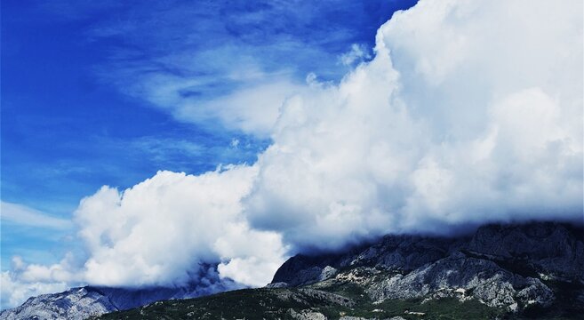 Big mountain with white clouds above and blue sky panoramic view
