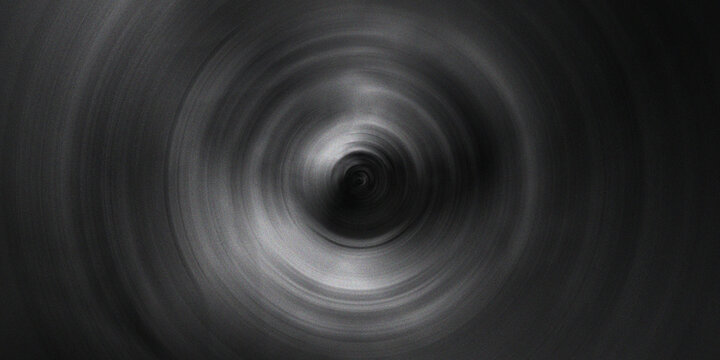 Radial motion blur tunnel effect with deep dark gray and black gradient tones creating spinning vortex illusion on dark surface.