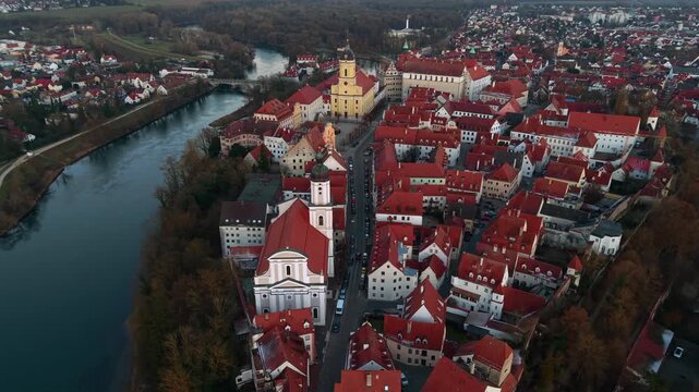 Aerial view of Neuburg an der Donau historic city center in Bavaria, Germany. Drone panorama of the old town red roofs, Danube river, Neuburg Castle, and Hofkirche church in beautiful morning light.