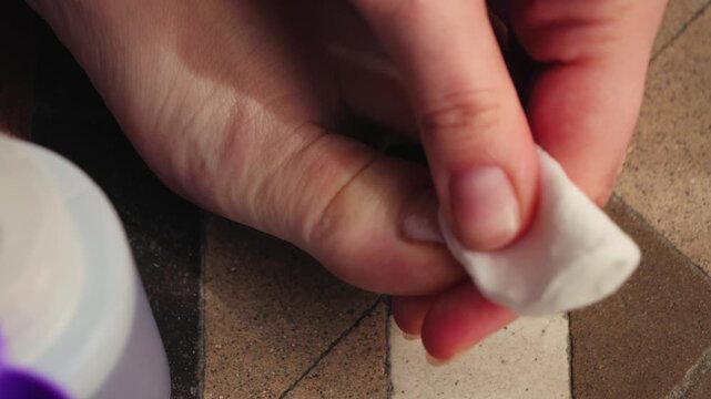 A close-up of feet being removed from toenails with a cotton pad and nail polish remover. Pedicure care, personal hygiene, beauty routine, and self-care at home concepts. High quality 4k footage