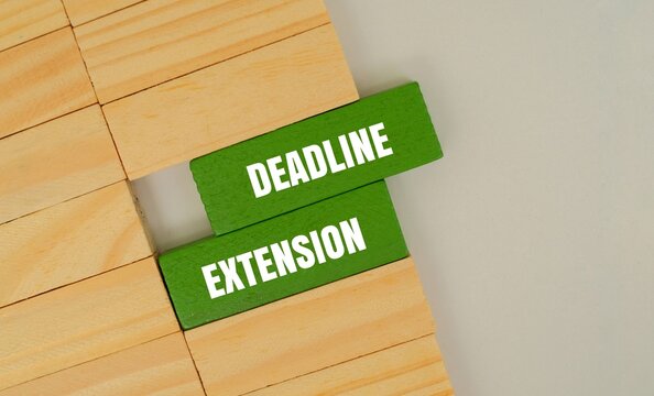 Wooden blocks with the words "DEADLINE  EXTENSION". Conceptualizing time management, business flexibility, project planning, and delayed schedules