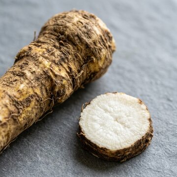 Fresh Horseradish Root and Slice on Gray Slate Surface, Organic Culinary Ingredient for Healthy Cooking and Gourmet Flavoring