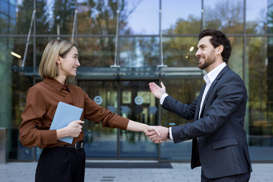 Business professionals sealing a successful partnership with a handshake outside a modern office building, symbolizing agreement, collaboration, and future growth