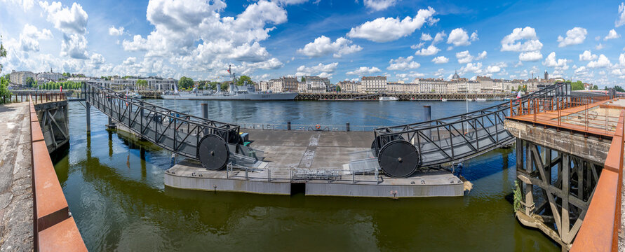 Nantes, France - 05 08 2026: Machines of the Isle. Panoramic view of La loire River, le Maill&eacute;-Br&eacute;z&eacute; a disarmed torpedo boat ship and buidings along Quai de La Fosse in sunny cloudy blue sky