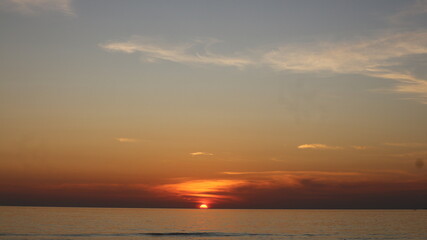 Obraz premium Sun dips low, painting sky in soft orange and pink hues