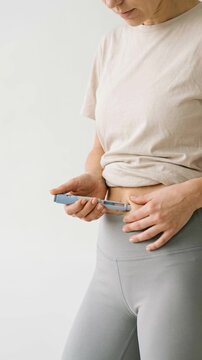 Woman preparing GLP 1 injection pen on light background with copy space, wellness treatment and healthy lifestyle concept.