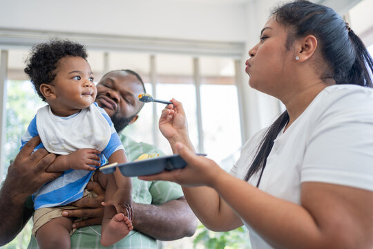Loving parents feeding their baby in a bright home environment. Promotes healthy parenting, emotional bonding, and modern family lifestyle through nurturing care and everyday connection