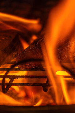 Flames dance around grilled meat at a summer barbecue in the backyard on a warm evening