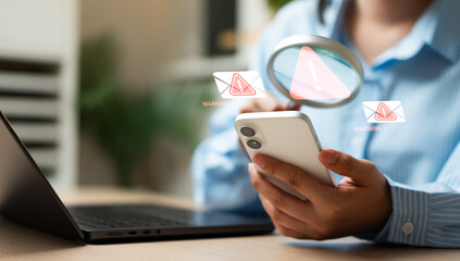Businesswoman using magnifying glass to detect spam email and cyber scam messages, representing hacker warning, spyware protection, data security, and global network cybersecurity. © Father_Studio