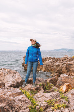 Adventure woman standing on rocky coastline