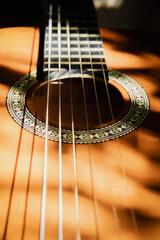 Obraz premium Close-up details of an acoustic guitar with natural light and shadow contrast. Artistic music background and texture concept.
