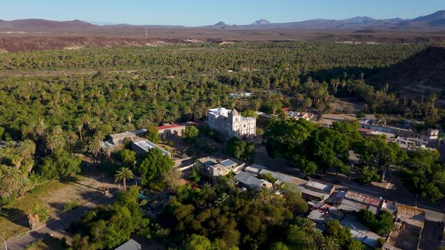 Explore the aerial view of Mission Church in San Ignacio, Baja California while taking in the surrounding oasis and landscape