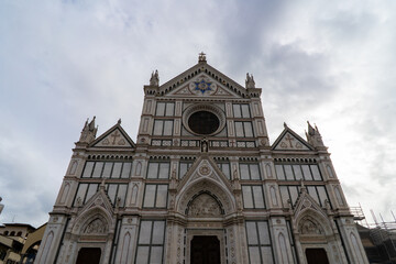 Fototapeta premium The stunning marble facade of the Basilica di Santa Croce, a renowned church in Florence, Italy, under a cloudy sky
