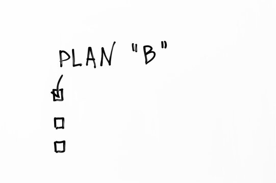 Plan B handwritten on whiteboard with checkboxes. Alternative strategy or backup plan option checked with a tick. Concept of business planning and risk management.