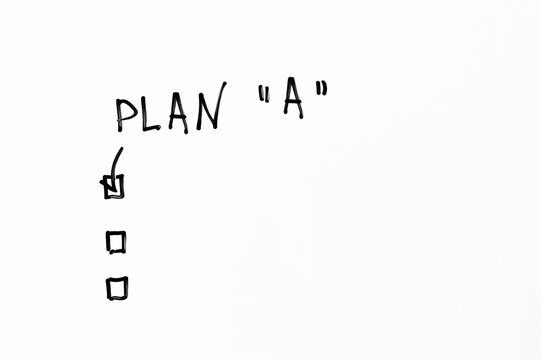 Plan A handwritten on whiteboard with checkboxes. First strategy option checked with a tick. Concept of business planning, strategy execution, and decision making.