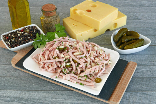Klassischer Schweizer Wurstsalat mit Emmentaler K&auml;se und Gew&uuml;rzgurken.