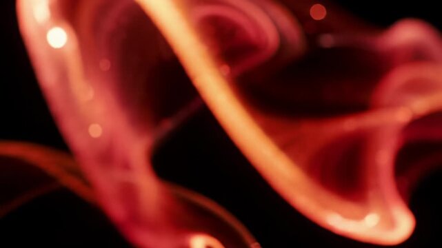 Extreme close-up video of mesmerizing iridescent molten red and orange fluid unfurling, coiling on black, pulsating with ethereal light, gentle push-in for cosmic beauty and hypnotic meditation