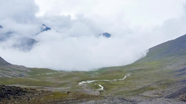 Aerial video of a rocky Old Silk Road trekking route during heavy rain and thick fog in Xinjiang, China.