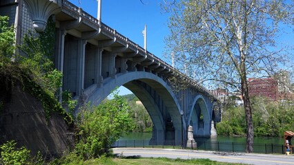 Fototapeta premium Beautiful Arched bridge crossing peaceful southern river in Fairmont, West Virginia on summer day 