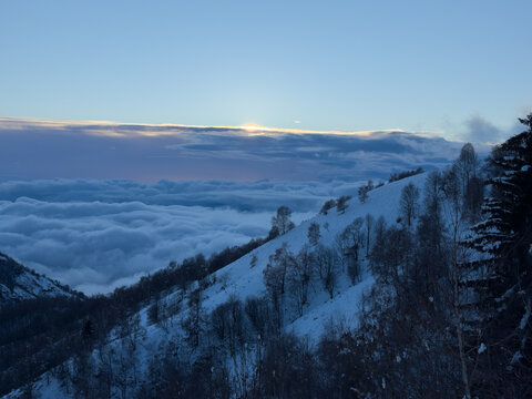 on the snow-capped peak of Mount Mottarone, Clouds moving in the valley at sunset.