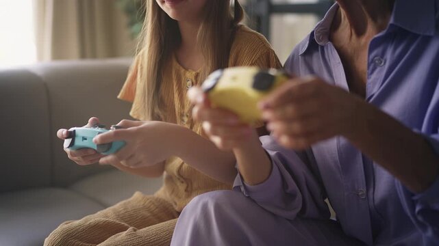 Senior woman and her grandchild playing video game with gamepads, losing match