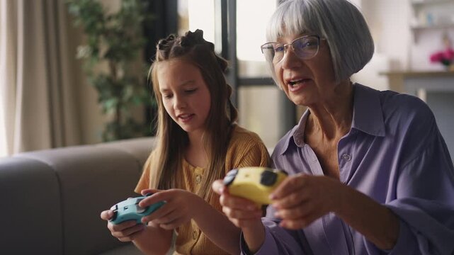 Excited young girl competing with granny in video game, frustrated by defeat
