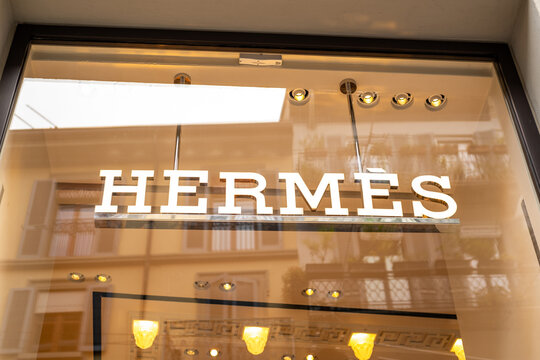 Herm&egrave;s Luxury Boutique Storefront Sign Reflected in Window With Warm Interior Lights  Milan Italy May 14, 2026