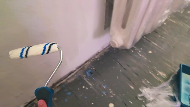 roller applying primer on interior wall during renovation