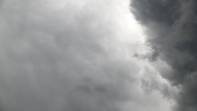 Dark storm clouds gathering and rolling across overcast sky in timelapse