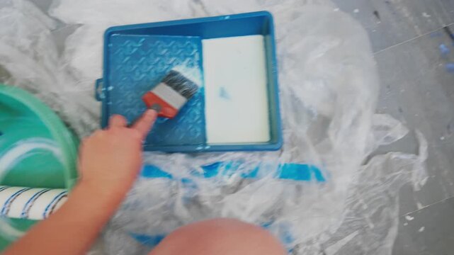 Hand brushing primer onto interior wall during room renovation