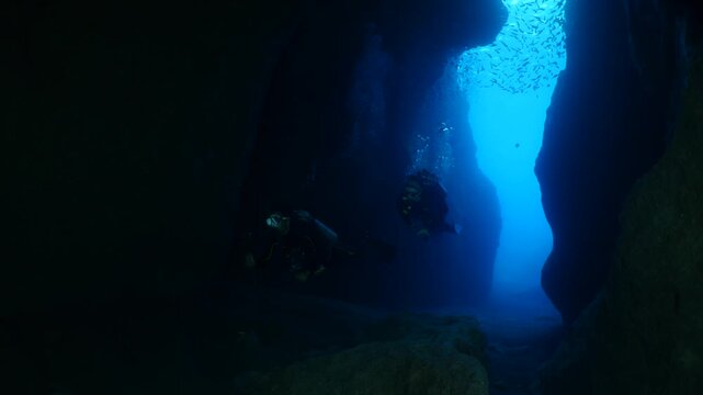 cave diving underwater scuba divers exploring caves and having fun ocean scenery sun beams and rays background